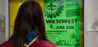 Pfadfinderin schaut auf ein Wiesenfestplakat